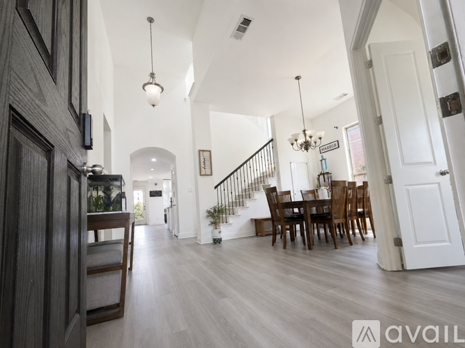 A modern house interior with a dining area and a staircase.