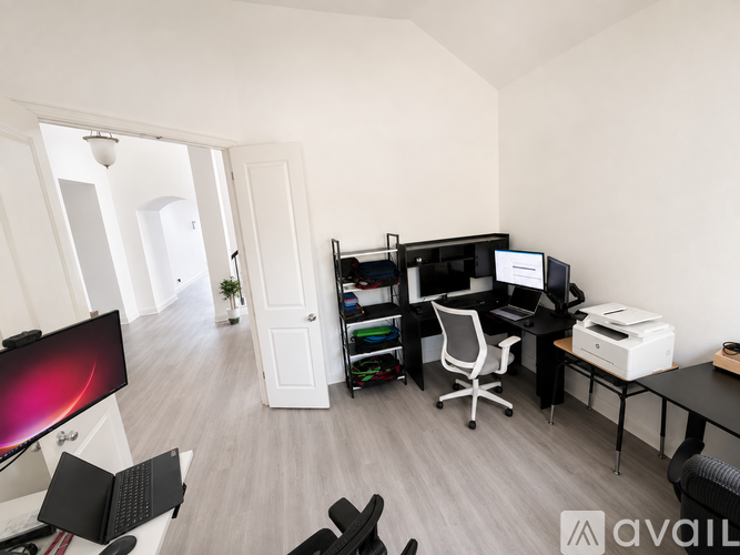 A modern home office with a desk, chair, and computer setup.