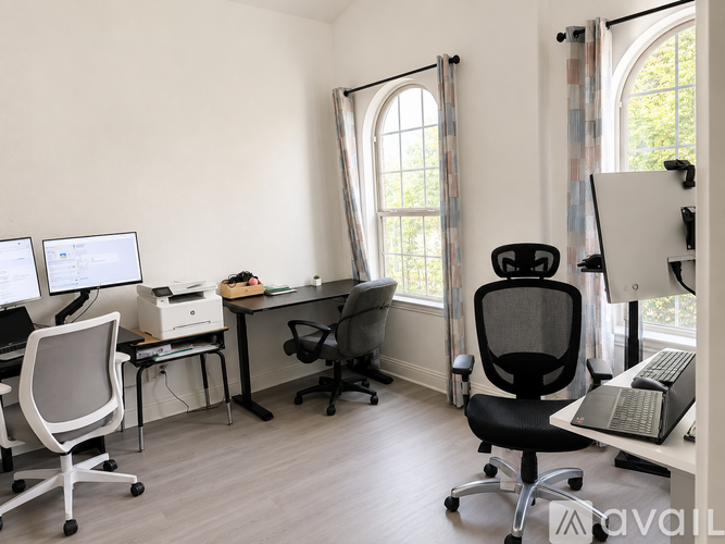 A white room with a desk and chairs.