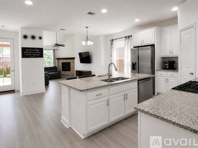 A modern kitchen with white cabinets and a granite countertop.