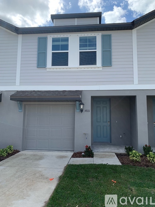 A house with a grey garage door and a blue door.