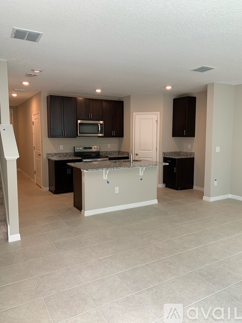 A kitchen with a granite countertop and a microwave above it.