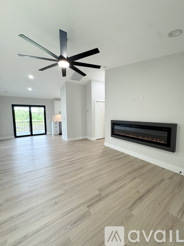 A modern living room with a fireplace and a ceiling fan.