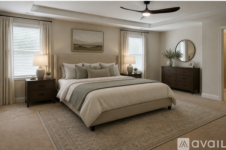 A bedroom with a large bed, a ceiling fan, and a painting on the wall.