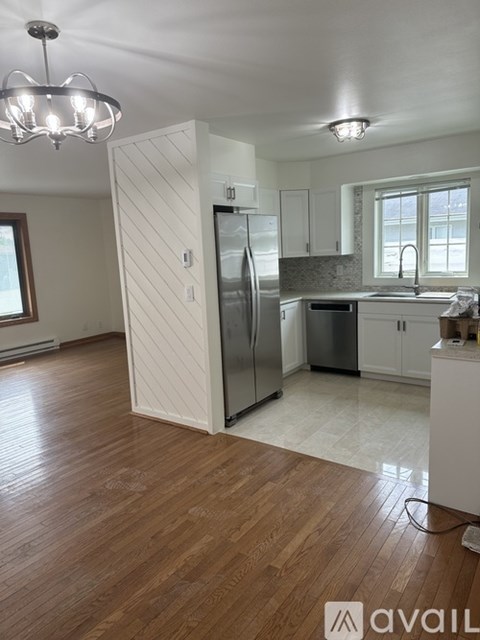 A kitchen with wooden floors and white walls.