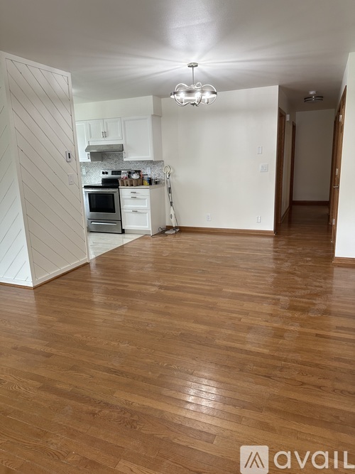 A kitchen with white cabinets and a wooden floor.