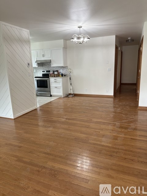 A kitchen with white cabinets and a wooden floor.