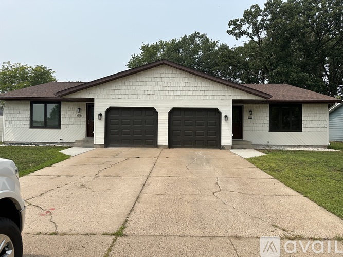 A two-car garage with a white exterior and a brown roof.