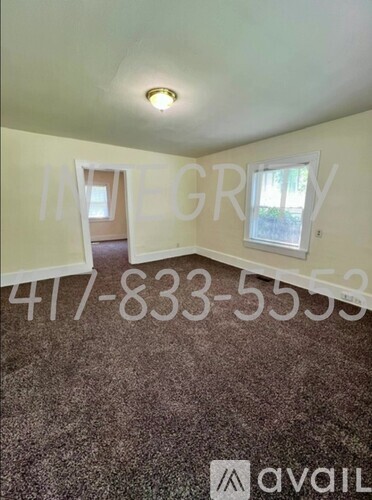 A room with a carpeted floor and a window.