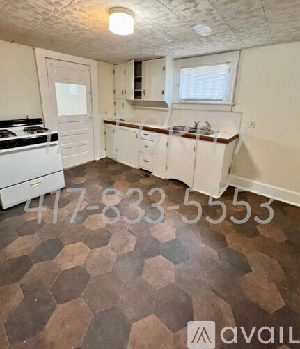 A kitchen with a tile floor and a stove top oven.