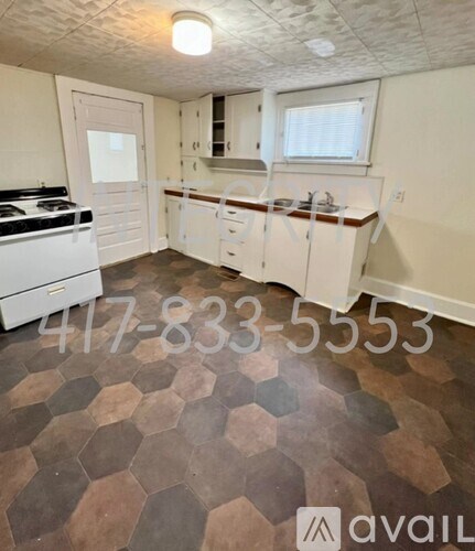 A kitchen with a tile floor and a stove top oven.