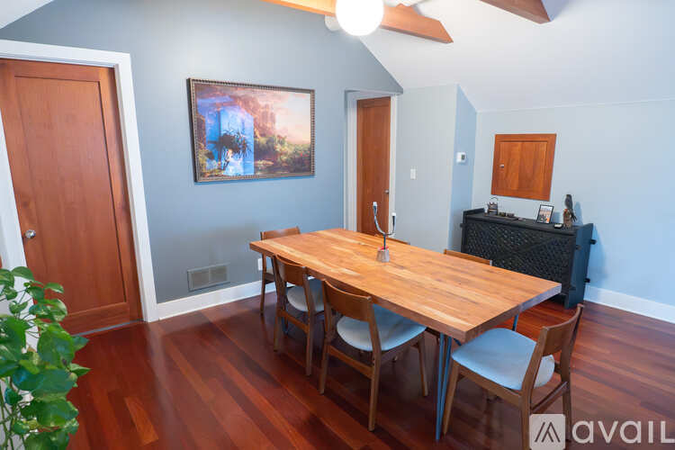 A dining room with a wooden table and chairs.