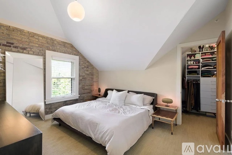A bedroom with a large bed and a brick wall.