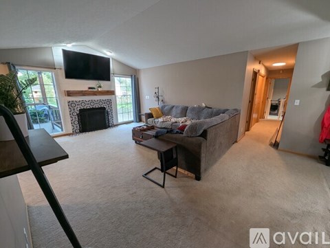 A living room with a fireplace and a television on the wall.
