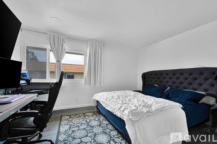 A bedroom with a large bed and a desk with a computer.