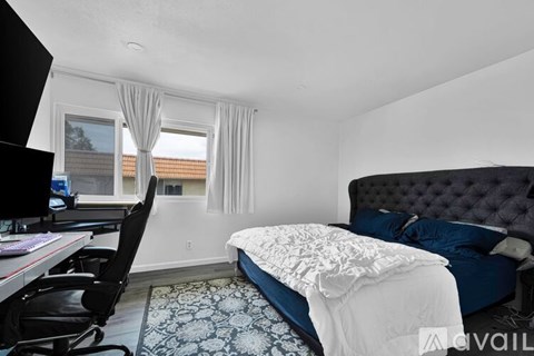A bedroom with a large bed and a desk with a computer.