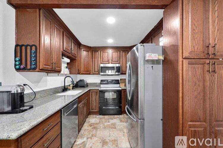 A kitchen with wooden cabinets and a granite countertop.