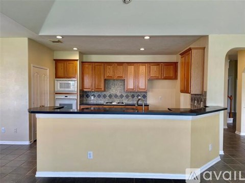 A kitchen with wooden cabinets and a black countertop.