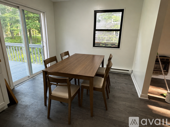 A dining room with a wooden table and chairs.