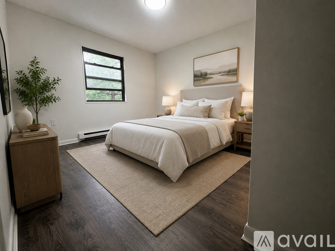 A bedroom with a large bed, a nightstand, and a plant.