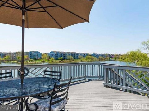 A patio with a table and chairs overlooking a body of water.