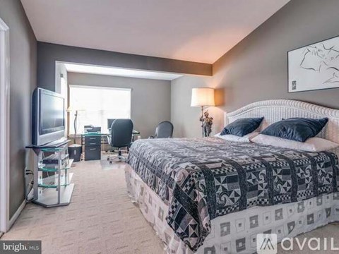A bedroom with a large bed and a television.