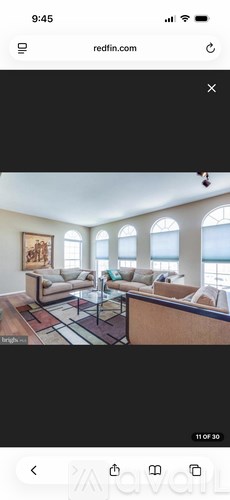 A living room with a couch, a coffee table, and a painting on the wall.