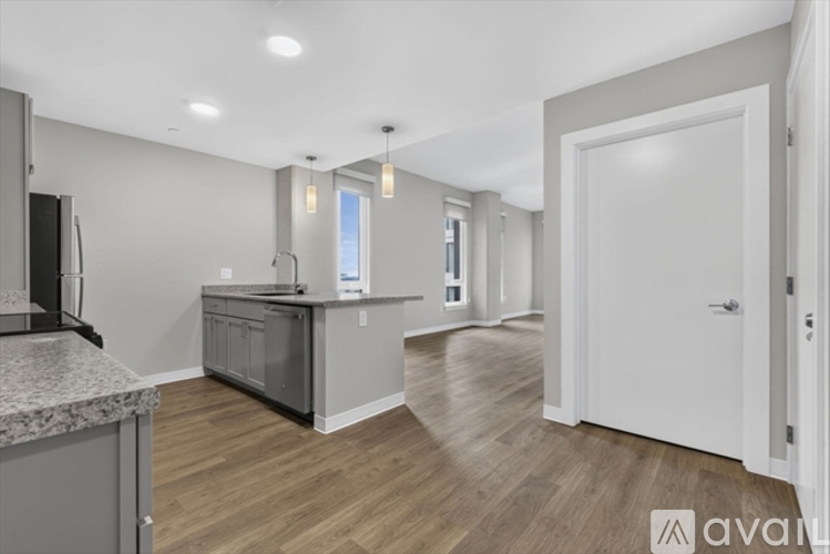 A kitchen with a granite countertop and wooden flooring.