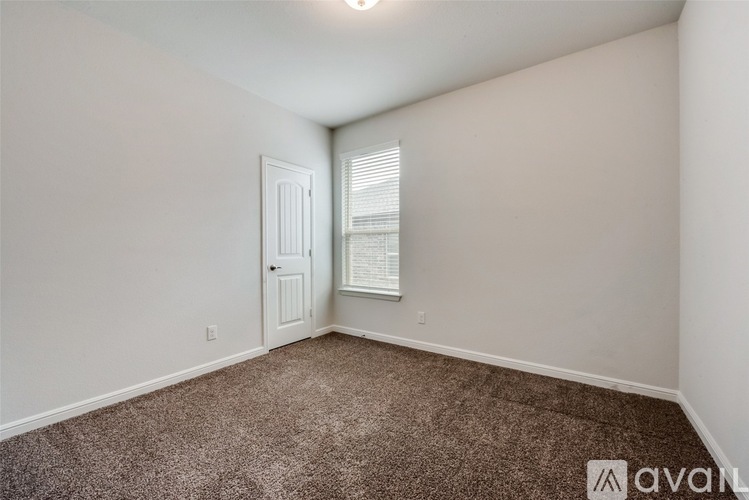 A spacious room with a carpeted floor and a ceiling fan.