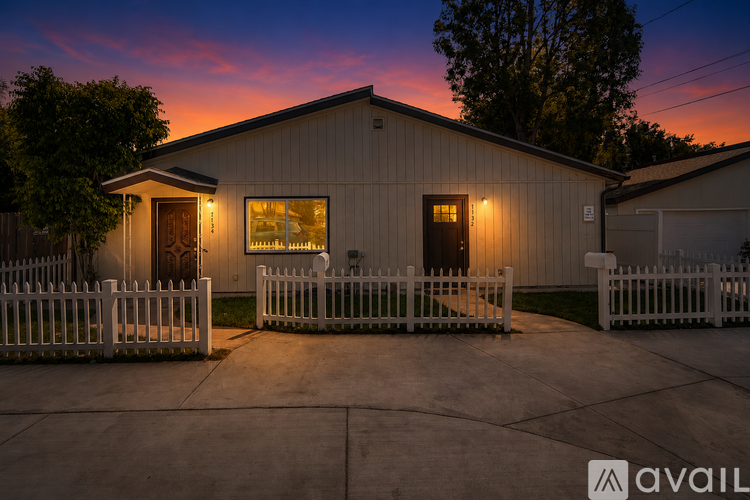 A house with a white picket fence is shown in the image.