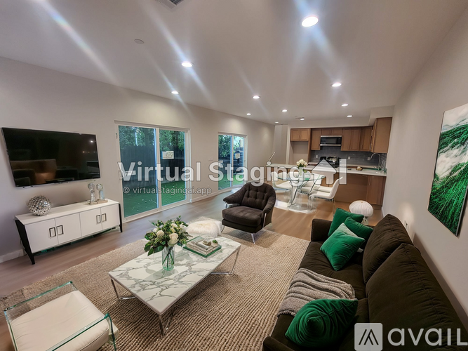A modern living room with a glass coffee table and a large painting on the wall.