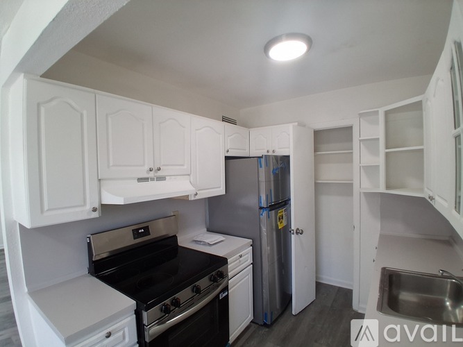 A kitchen with white cabinets and a black stove top oven.
