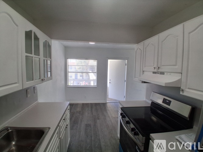 A kitchen with white cabinets and a black stove top oven.