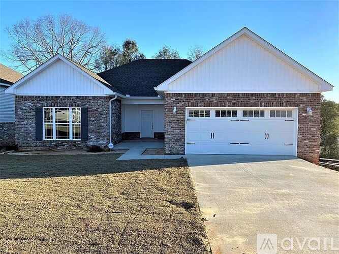 A two-car garage is attached to a house with a white brick exterior.