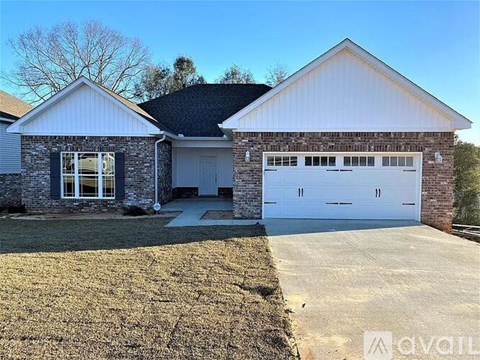 A two-car garage is attached to a house with a white brick exterior.