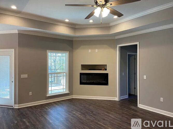 A spacious room with a fireplace and a ceiling fan.