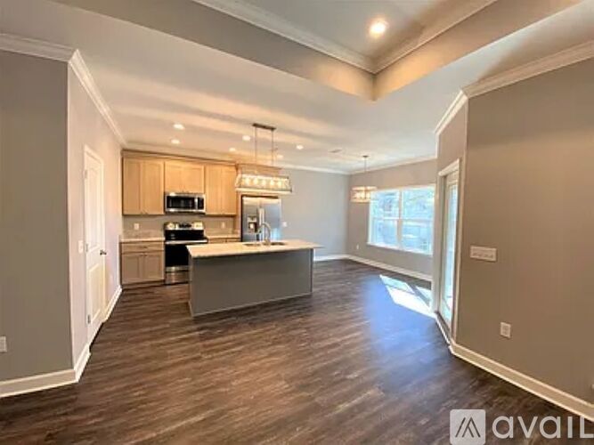 A spacious kitchen with wooden floors and a large island.
