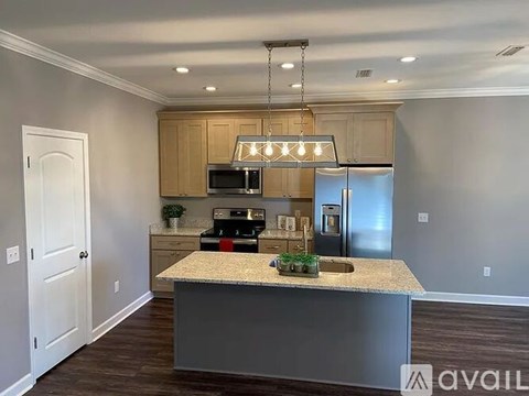 A kitchen with a granite countertop and a microwave above it.