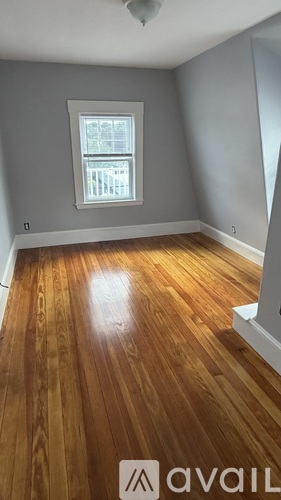 A room with wooden flooring and a window.