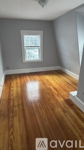 A room with wooden flooring and a window.