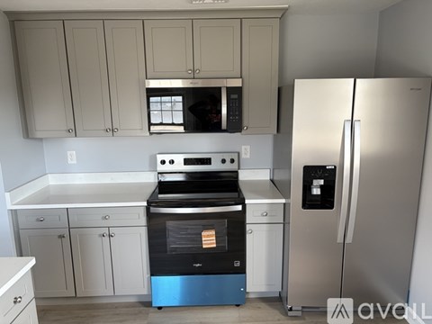 A modern kitchen with a stainless steel refrigerator and a black oven.
