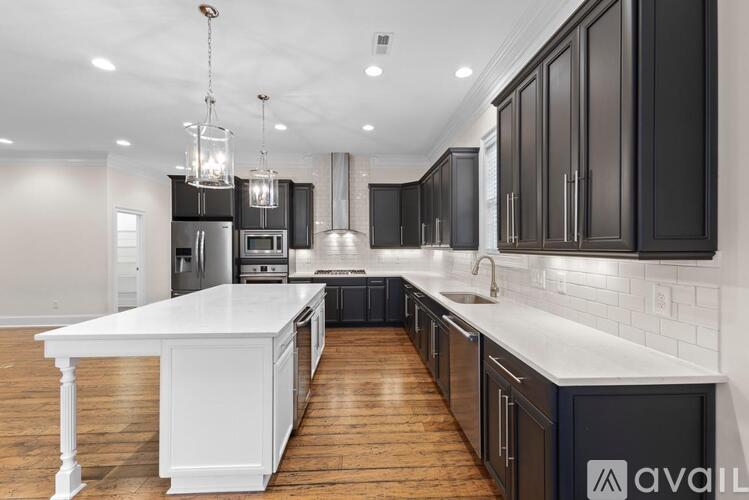 A modern kitchen with dark brown cabinets and white countertops.