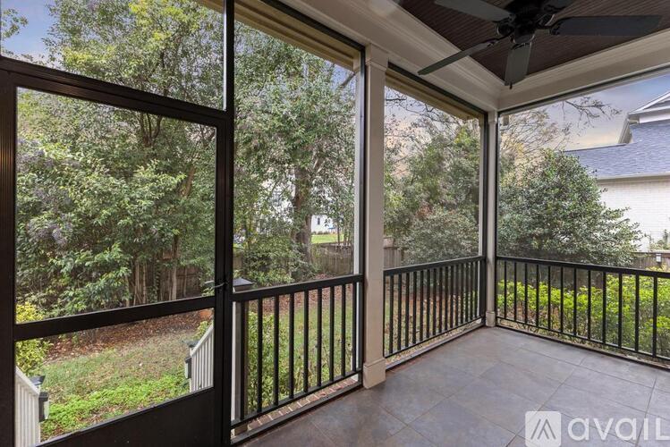 A balcony with a view of a green yard and trees.