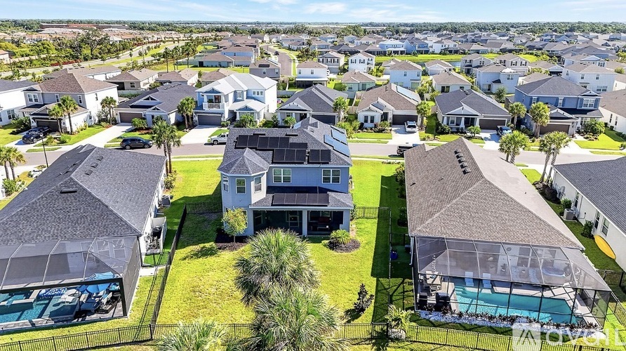 A bird's eye view of a residential area with houses and swimming pools.
