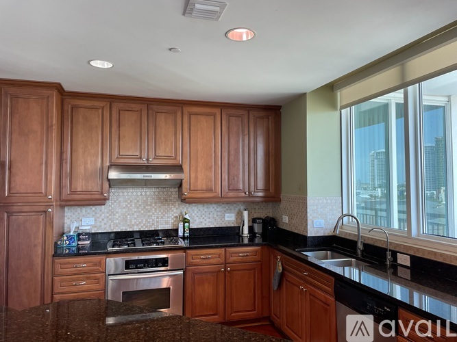 A kitchen with wooden cabinets and a black countertop.