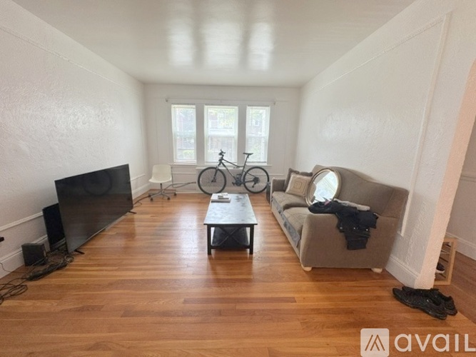 A living room with a television, a couch, and a bicycle in the background.