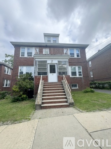 A brick building with a white door and steps leading up to it.