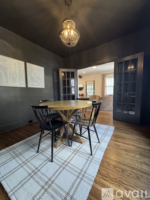 A dining room with a wooden table and chairs.