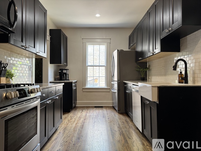 A kitchen with black cabinets and stainless steel appliances.