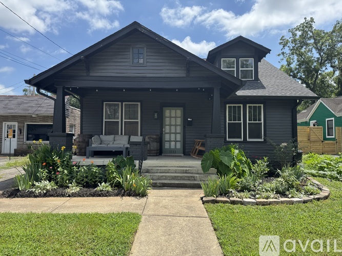 A house with a grey exterior and a front yard with plants.